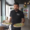 Ägaren serverar Pizzor 